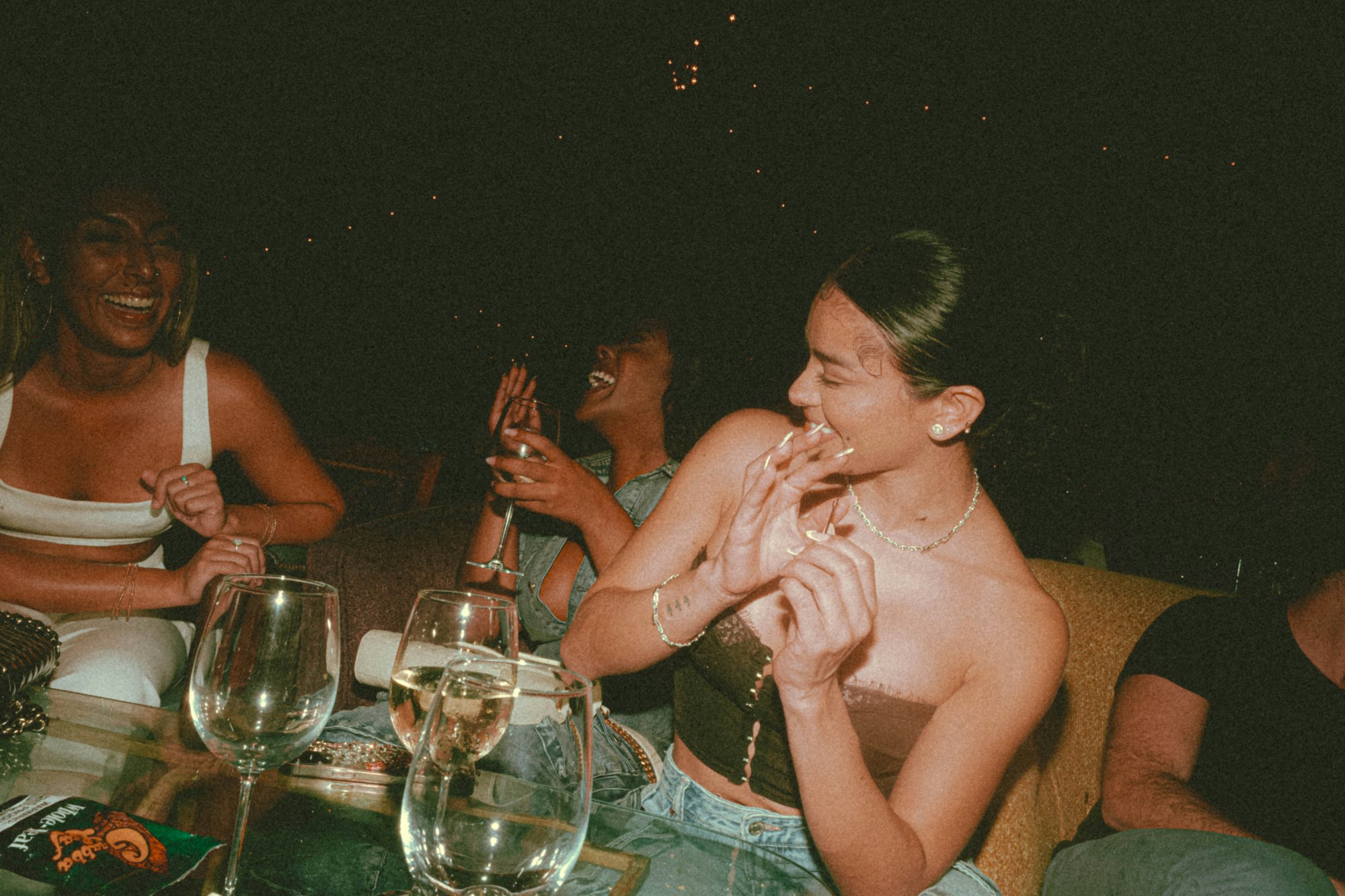 Friends laughing at a table at night